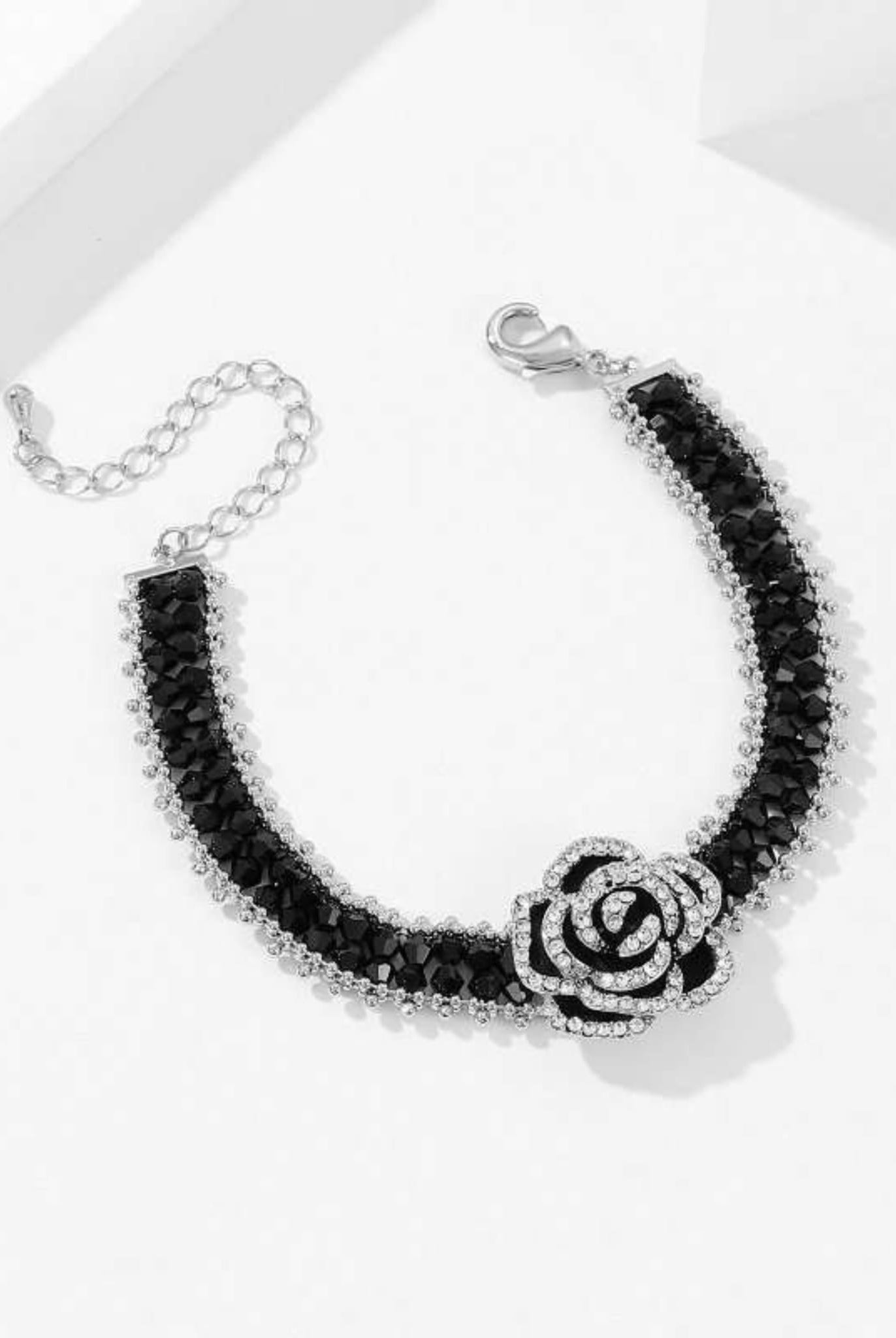 Elegant black camellia bracelet with faceted beads and crystal details.