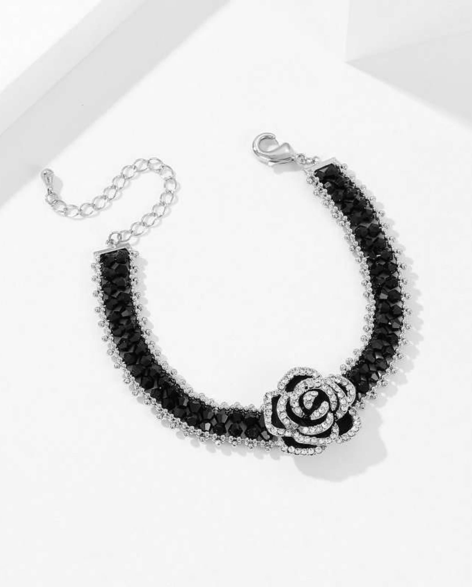 Elegant black camellia bracelet with faceted beads and crystal details.