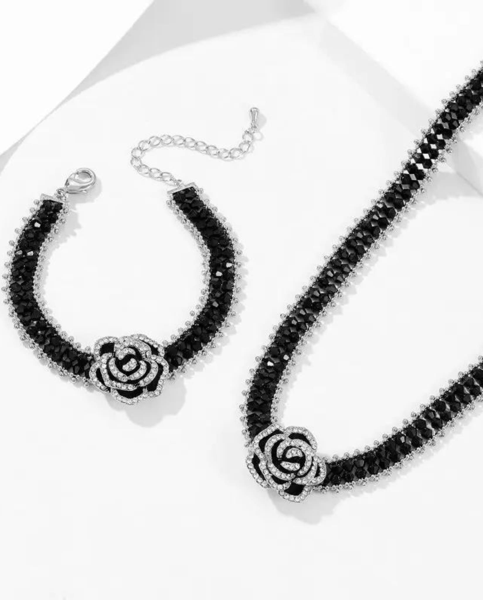 Adjustable black beaded bracelet with a crystal-studded camellia flower.