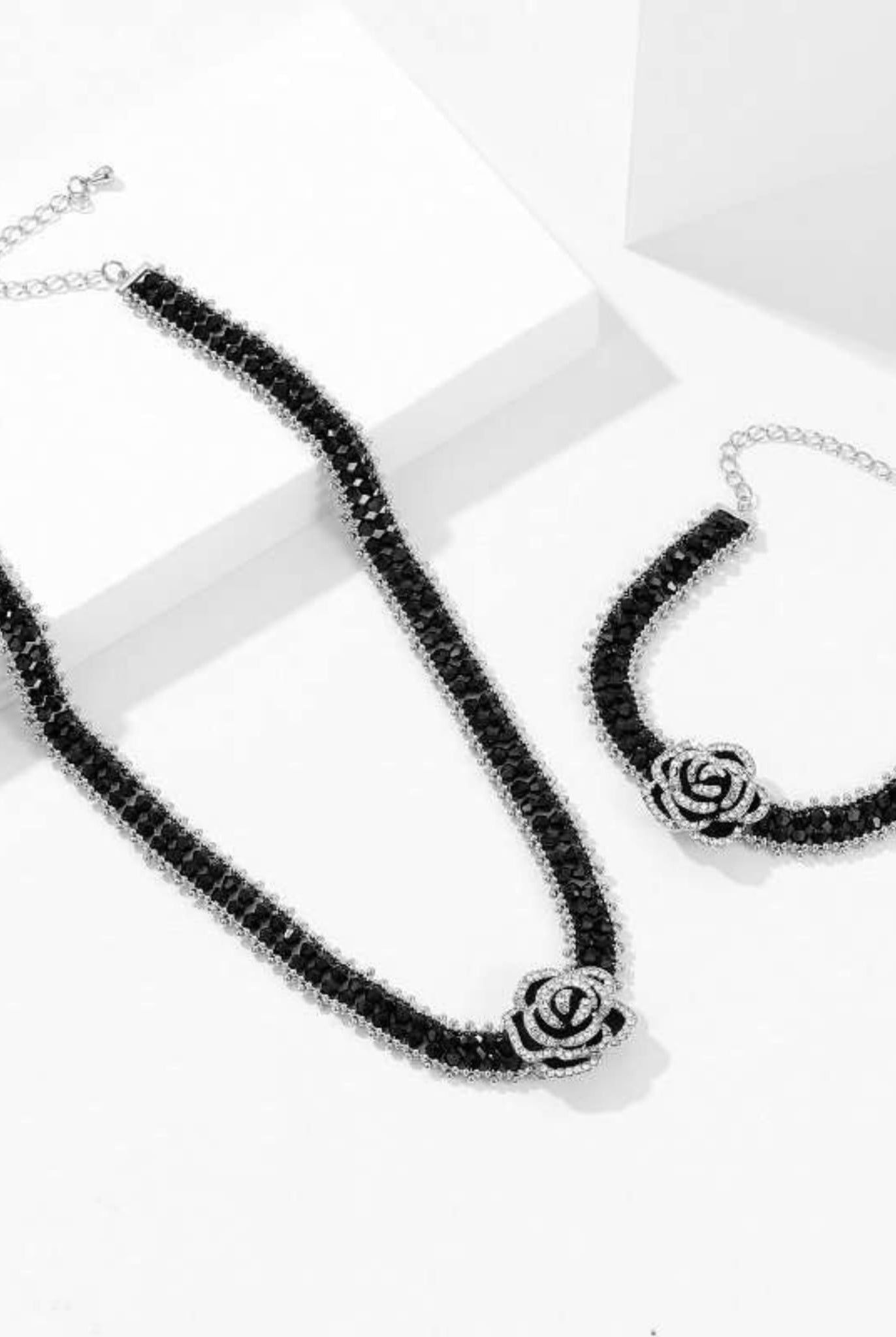 Black camellia bracelet and necklace set with sparkling crystals.
