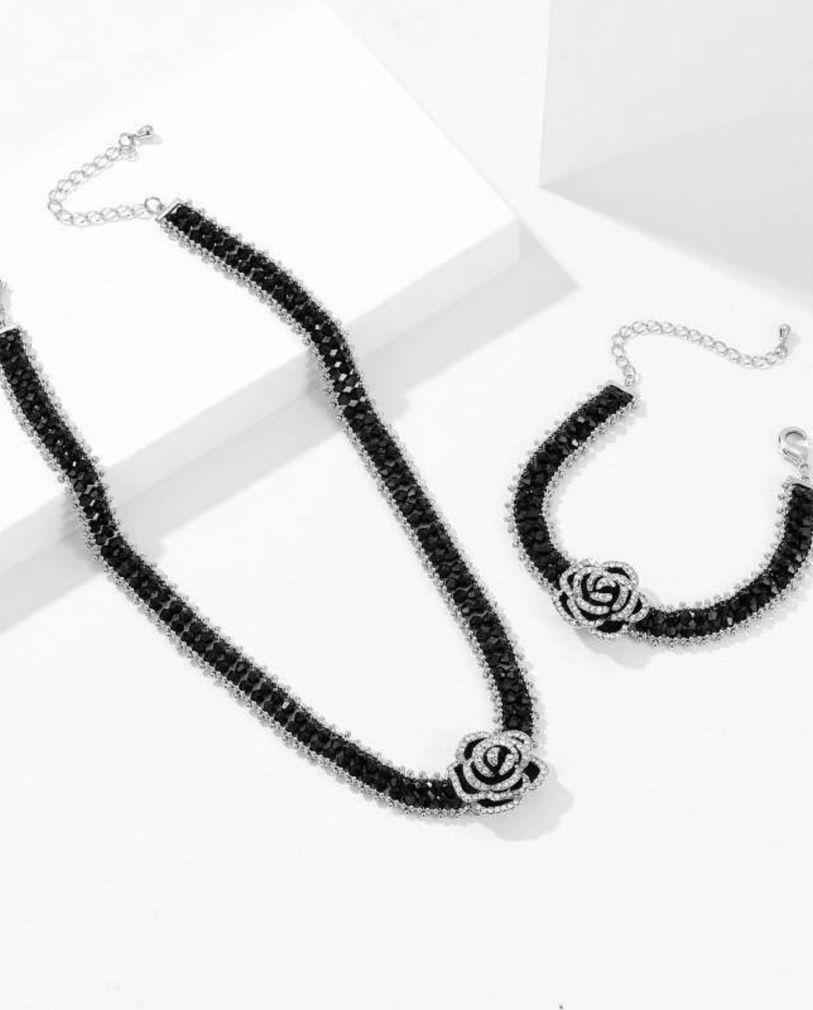 Black camellia bracelet and necklace set with sparkling crystals.