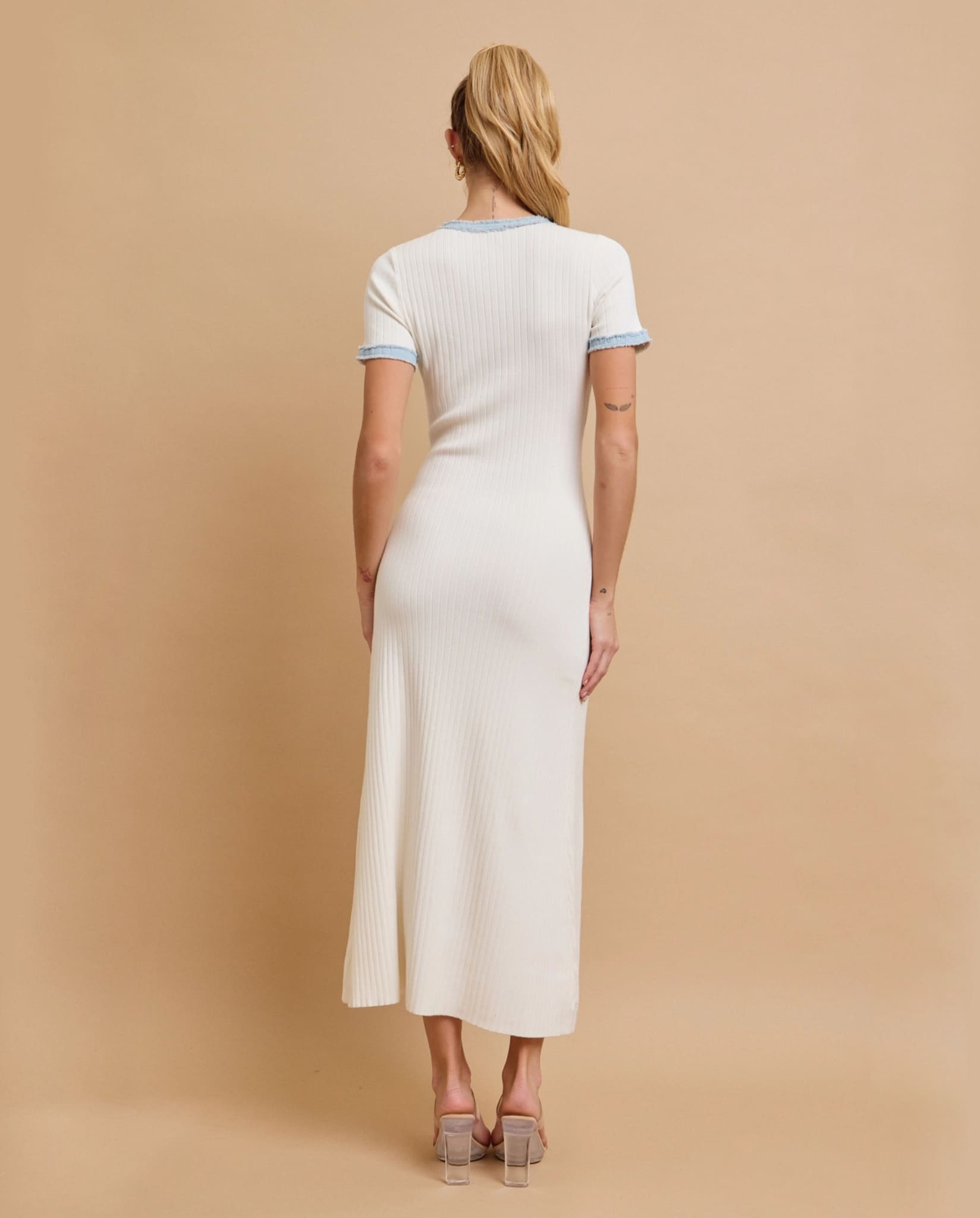 White ribbed knit dress back view with fitted silhouette.