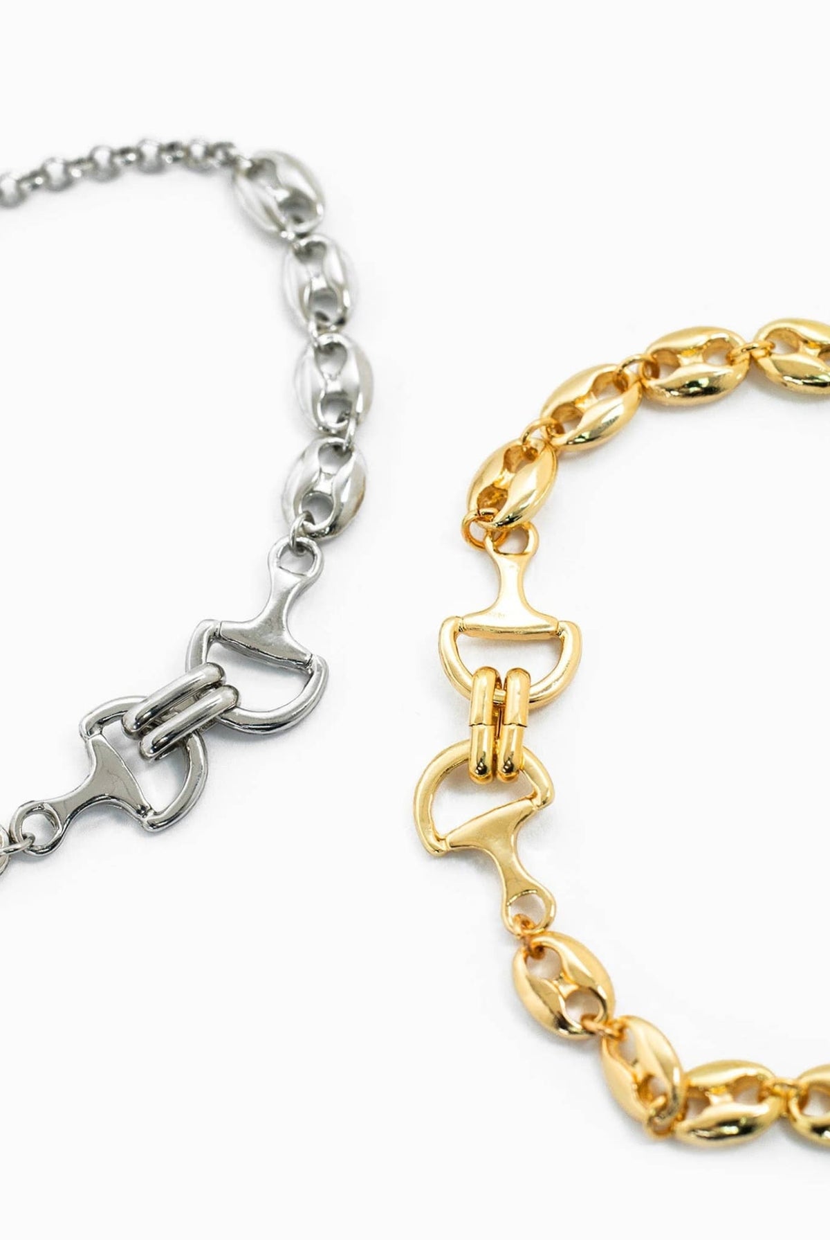 Close-up of gold and silver horse bit chain bracelets showing link and clasp details.