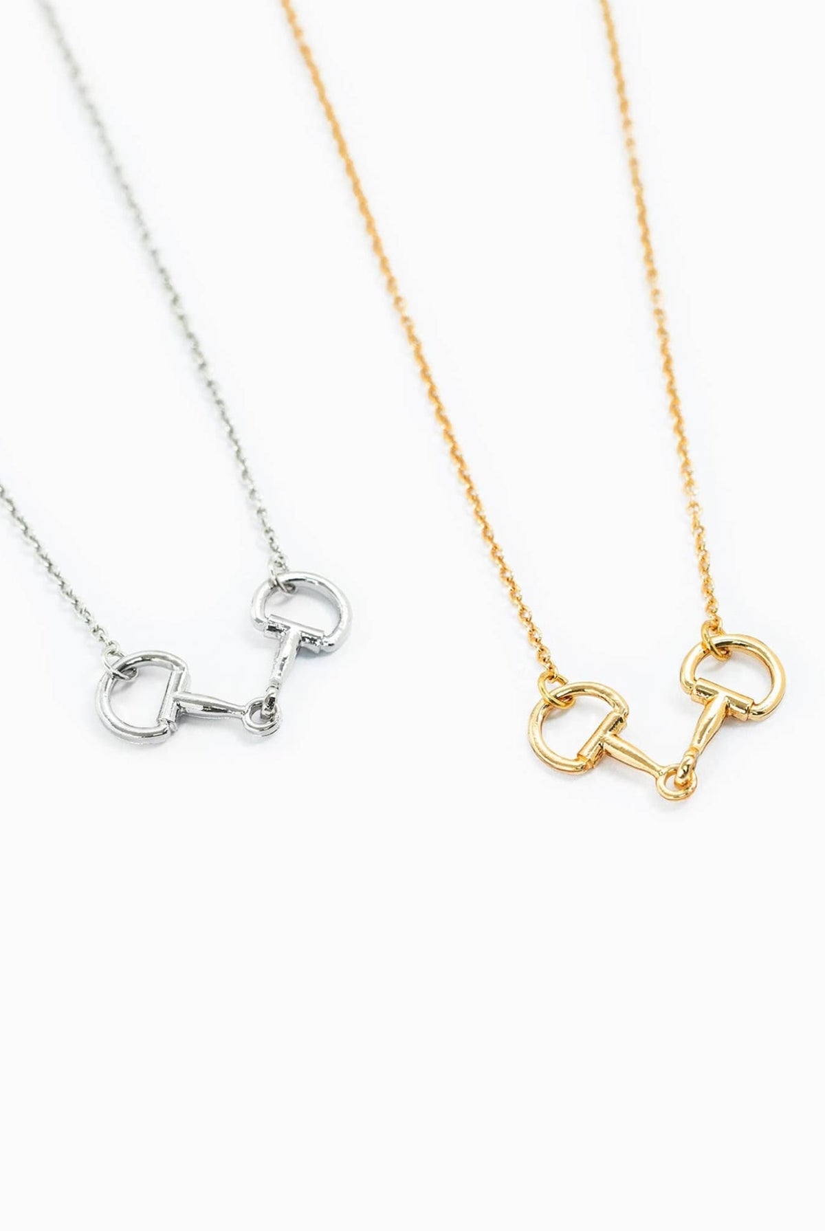 Gold and silver horse bit necklaces displayed together on white background.