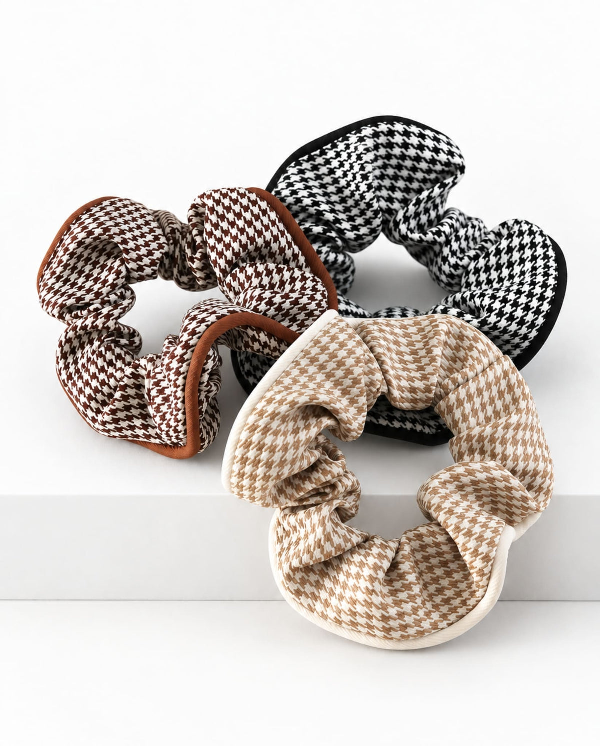 Brown, beige and black houndstooth hair scrunchies.