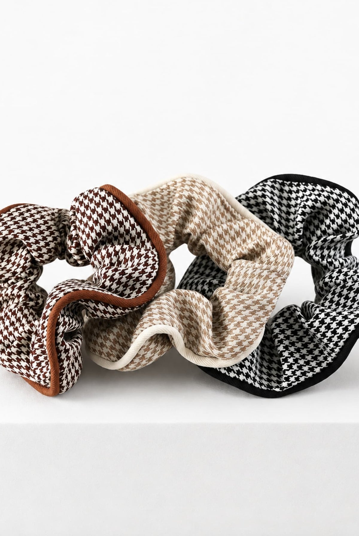 Houndstooth hair scrunchies in brown, beige and black.