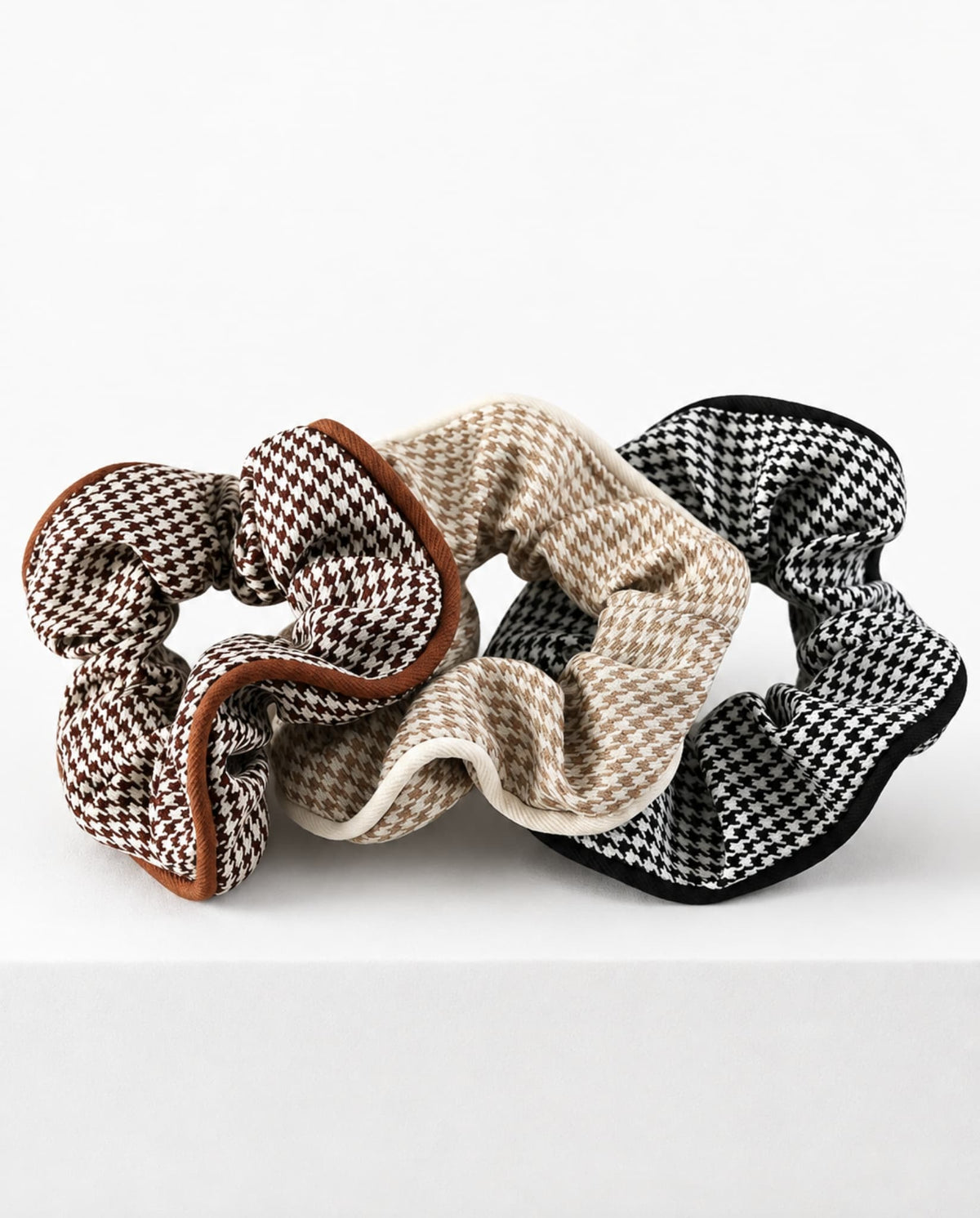 Houndstooth hair scrunchies in brown, beige and black.