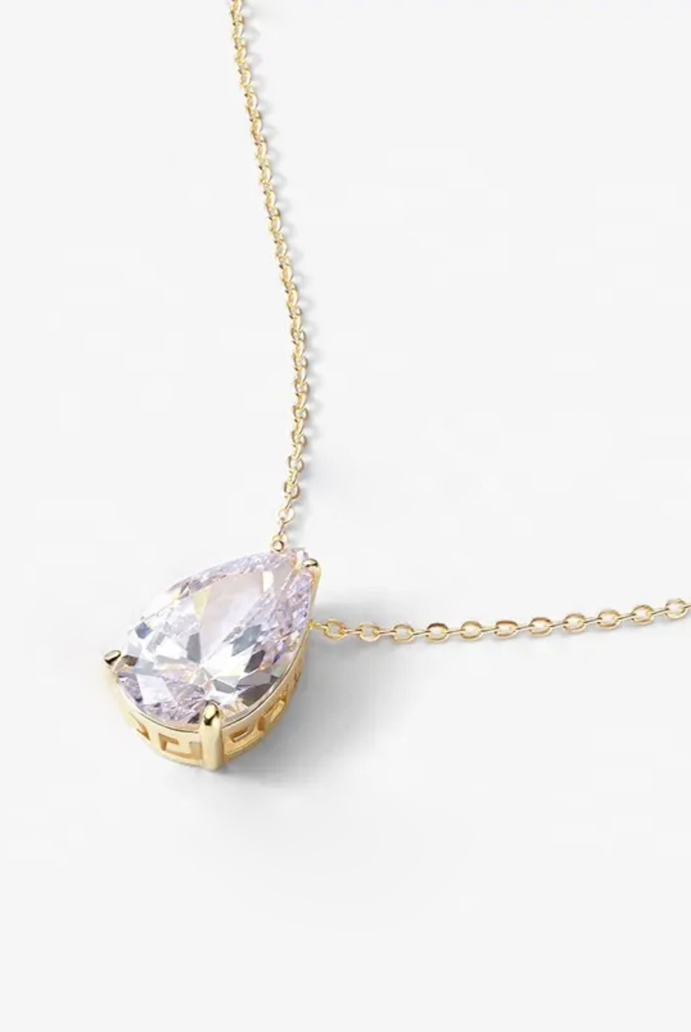 Detailed view of gold teardrop pendant with brilliant-cut stone and fine setting.