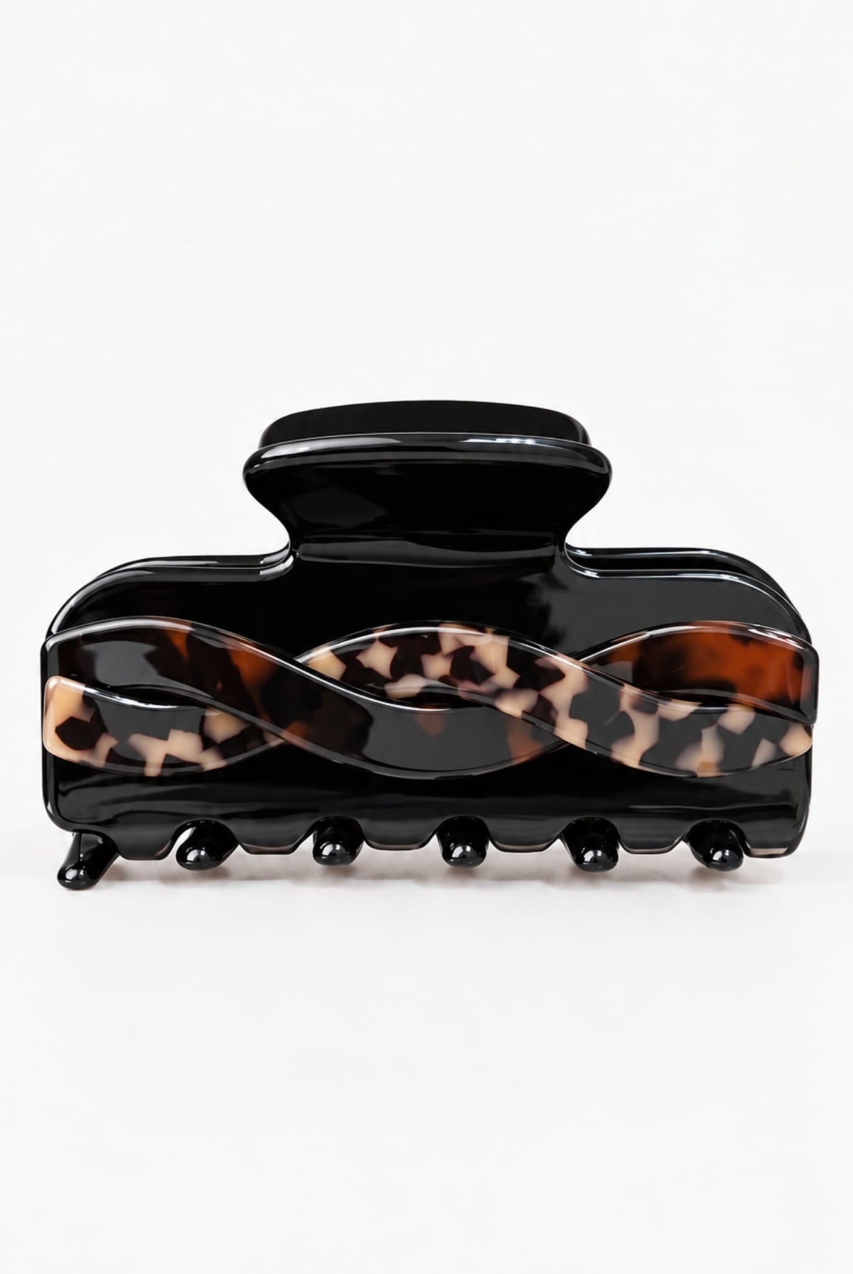 Front view of a black hair claw clip featuring a wavy tortoiseshell twist design and rounded teeth on a white studio background.