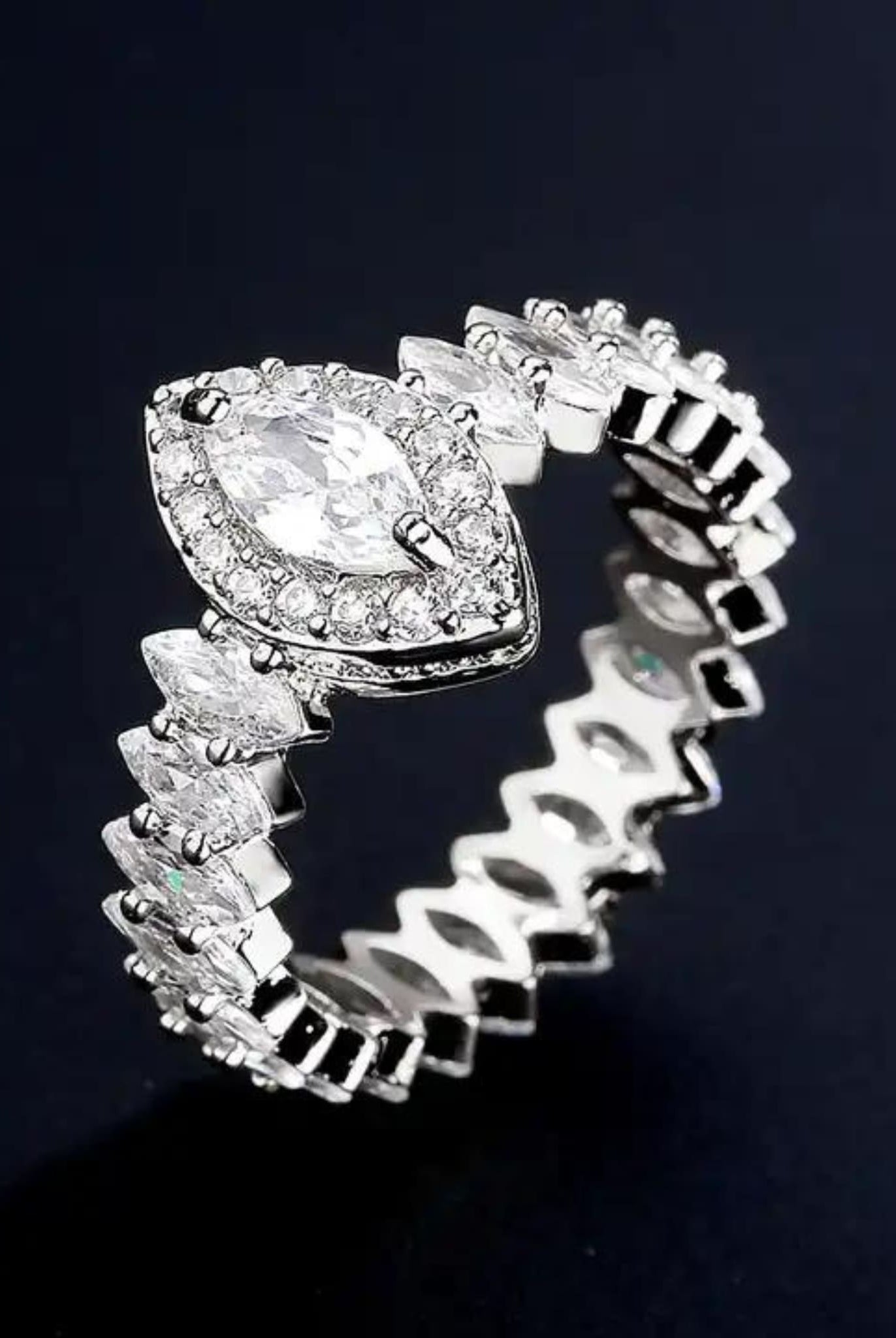 Detailed view of silver marquise ring with zircon stones.