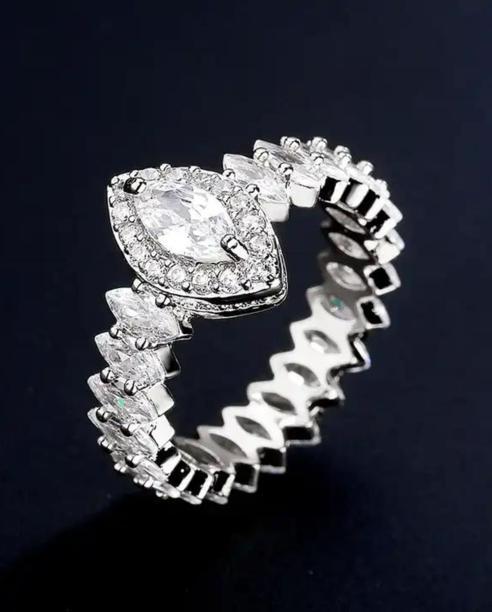 Detailed view of silver marquise ring with zircon stones.
