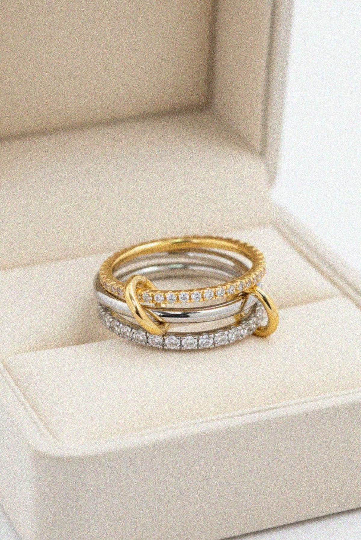 Sculptural interlocking design combining polished bands with crystal-set accents.