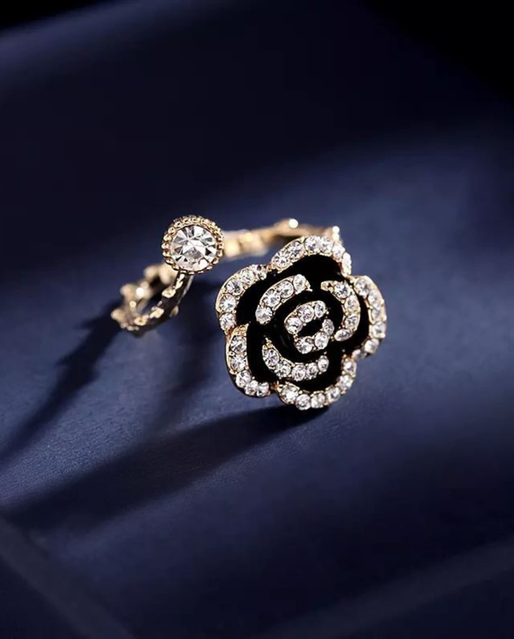 Gold open band Camellia Flower Ring with rhinestones and black enamel details.