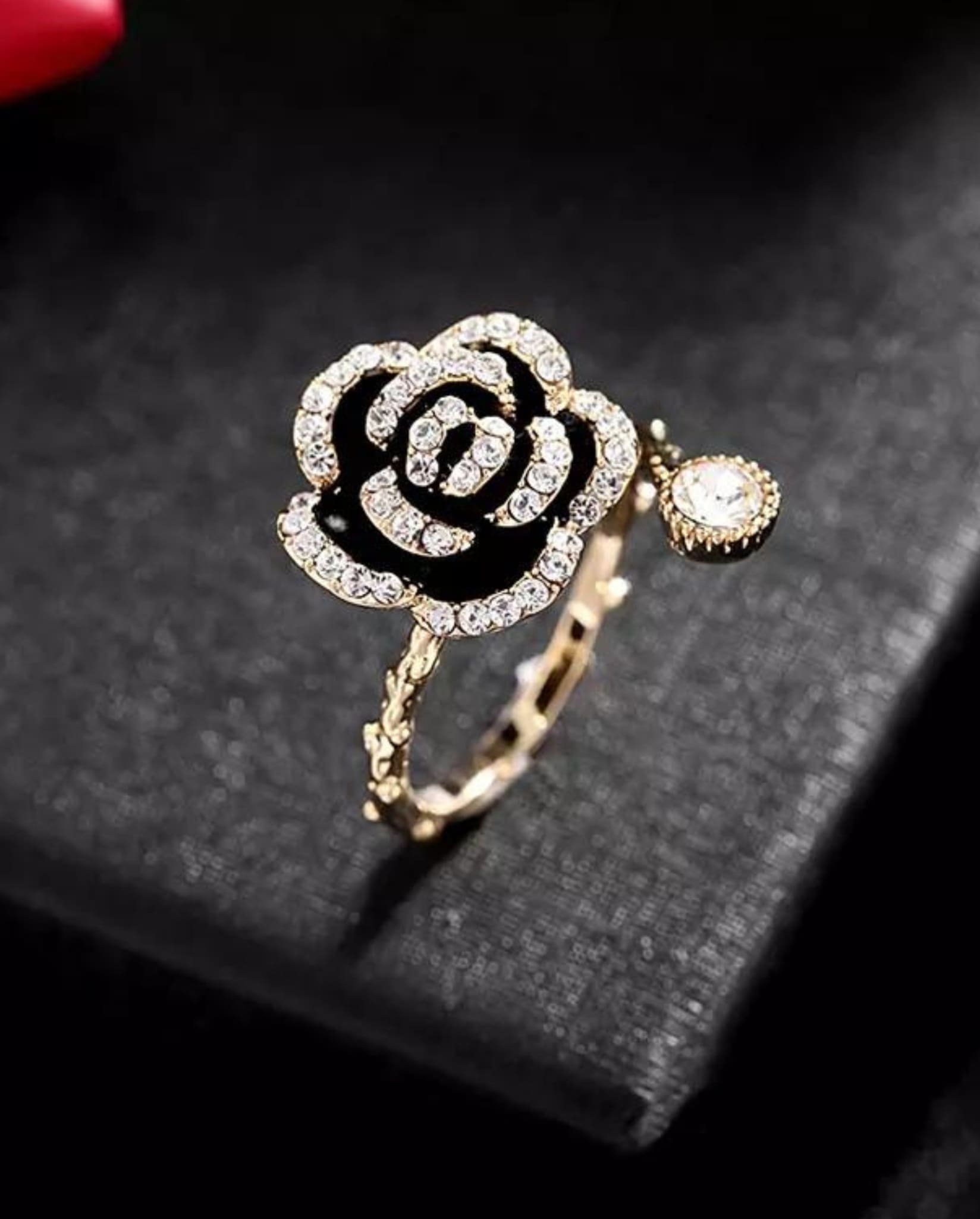 Gold floral ring with a black Camellia design and sparkling rhinestones.