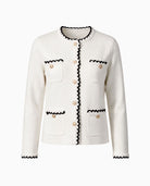 White cardigan with black and pearl trim, gold buttons and four front pockets.