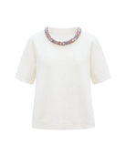 White knit top with multicolor crystal collar detail.