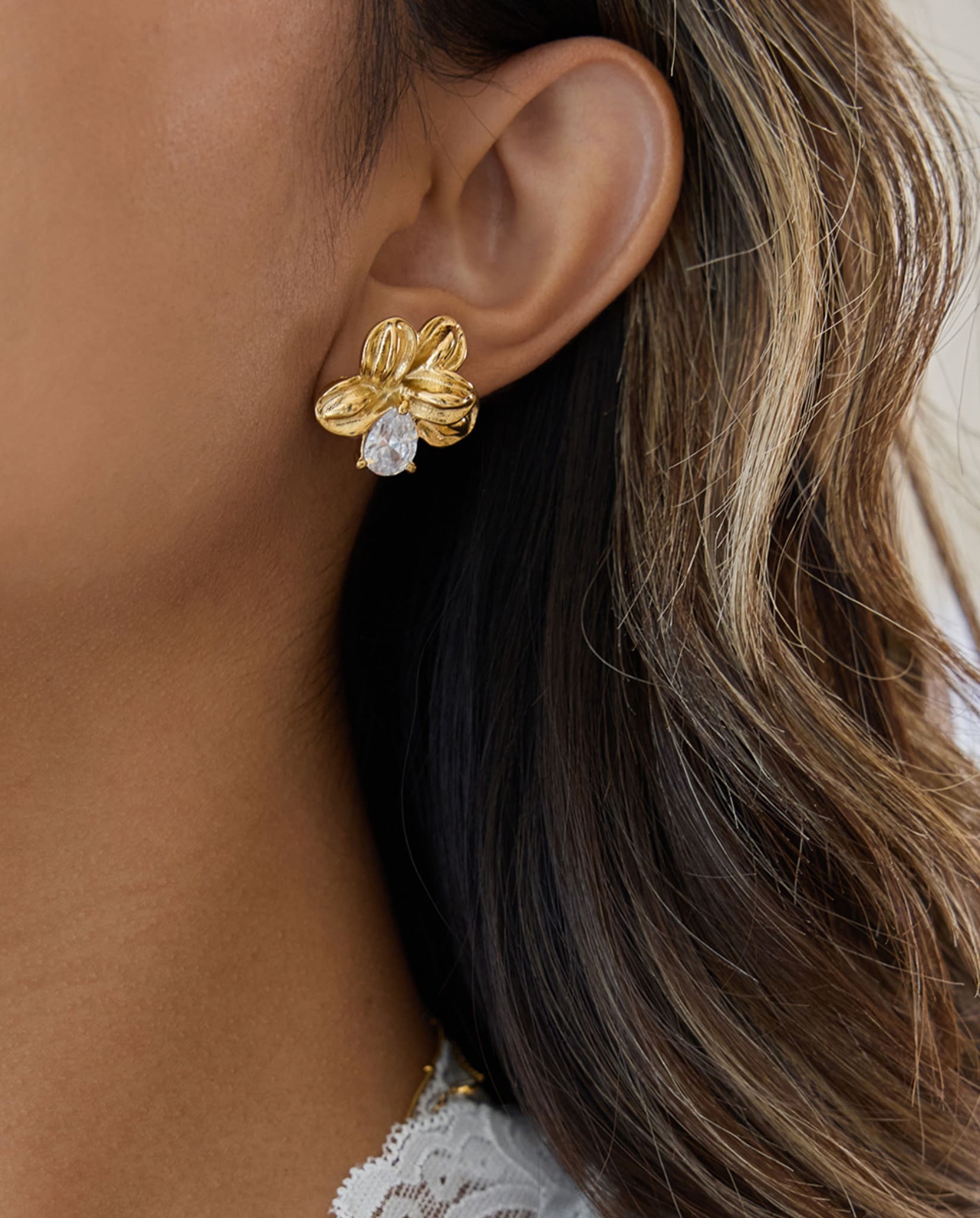 Gold-plated flower earrings with teardrop crystal worn on ear, Crystal Teardrop Flower Earrings