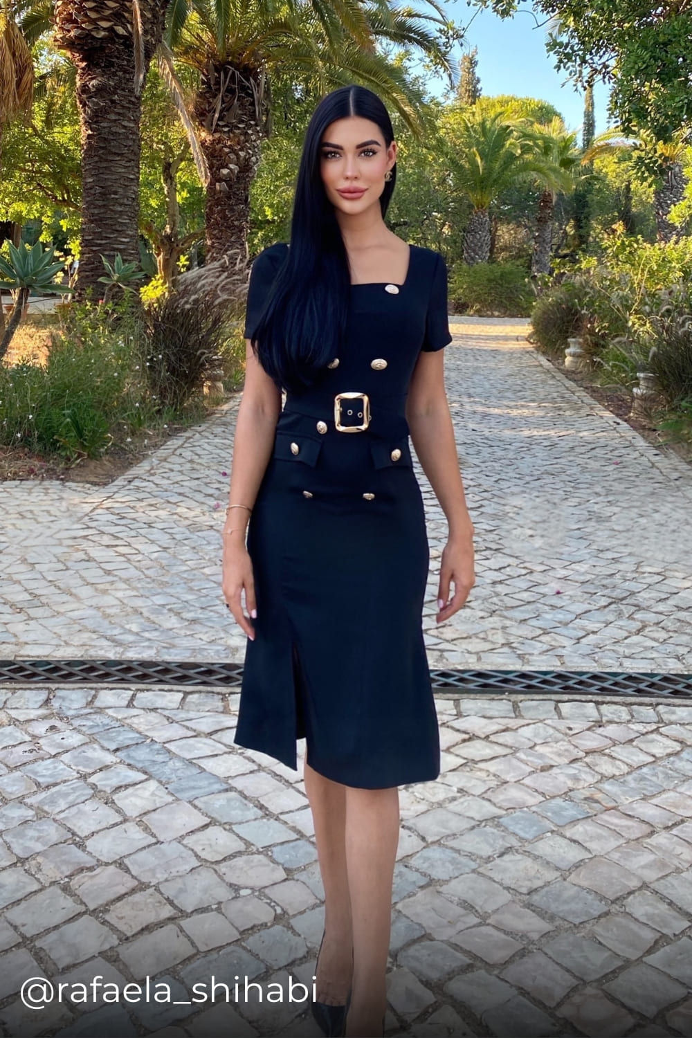 Rafaela wearing a belted midi dress with gold buttons from Coventina Collection