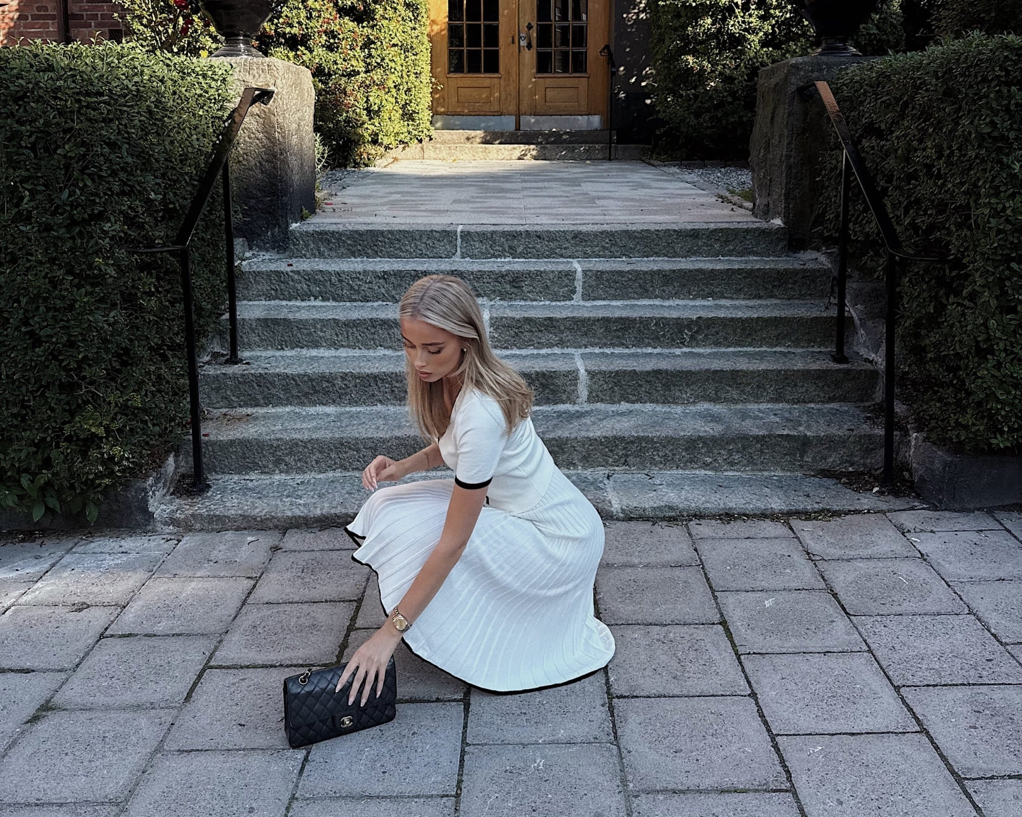 Olivia wearing a pleated skirt set in white from Coventina Collection