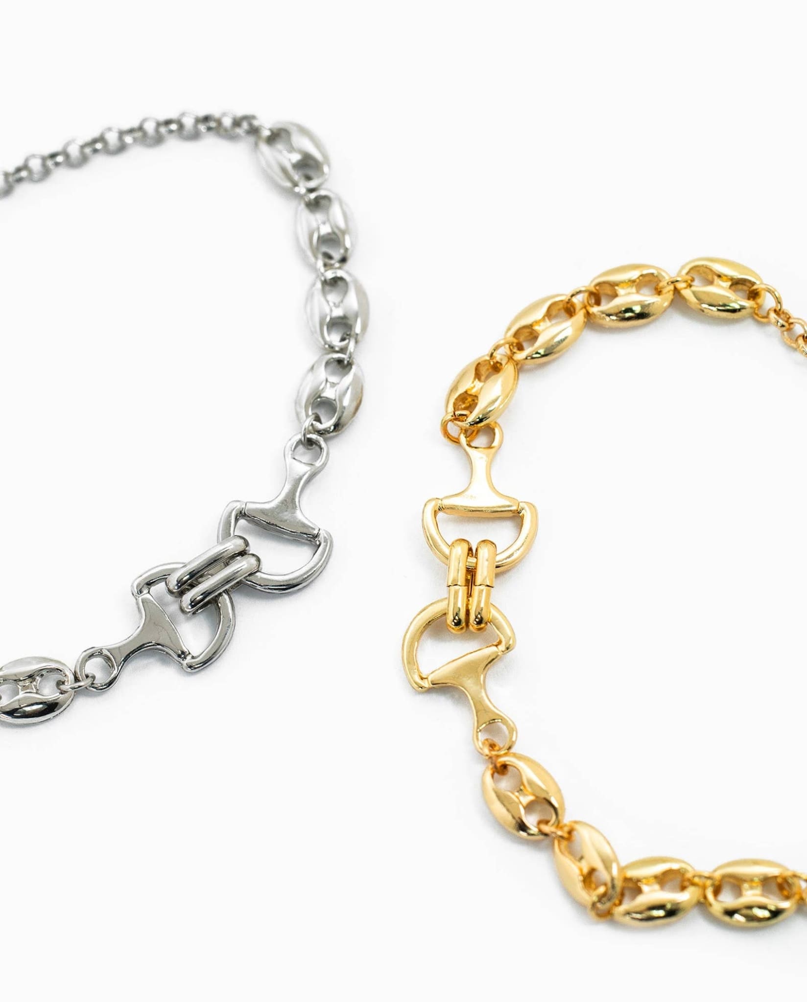 Close-up of gold and silver horse bit chain bracelets showing link and clasp details.