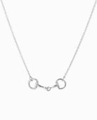 Silver chain necklace with horse bit pendant on white background.