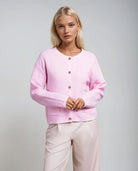 Women's powder pink textured cardigan with decorative buttons from Coventina Collection.