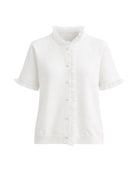 Short sleeve knit top in white with ruffle details and pearl buttons.