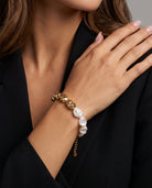 Sculpted Pearl Bracelet worn on the wrist with irregular white pearl beads and sculpted gold-tone beads.
