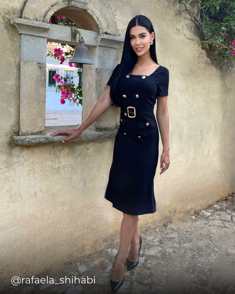 Rafaela wearing a belted midi dress with gold buttons from Coventina Collection