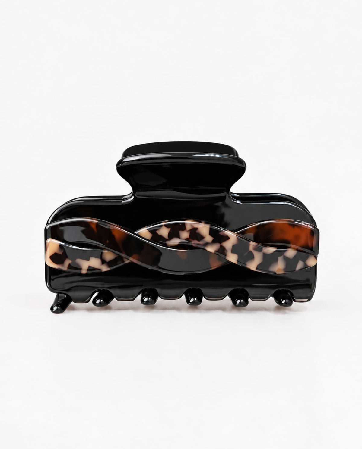 Front view of a black hair claw clip featuring a wavy tortoiseshell twist design and rounded teeth on a white studio background.