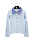 Striped collar cardigan in blue with gold buttons from Coventina Collection displayed on hanger.