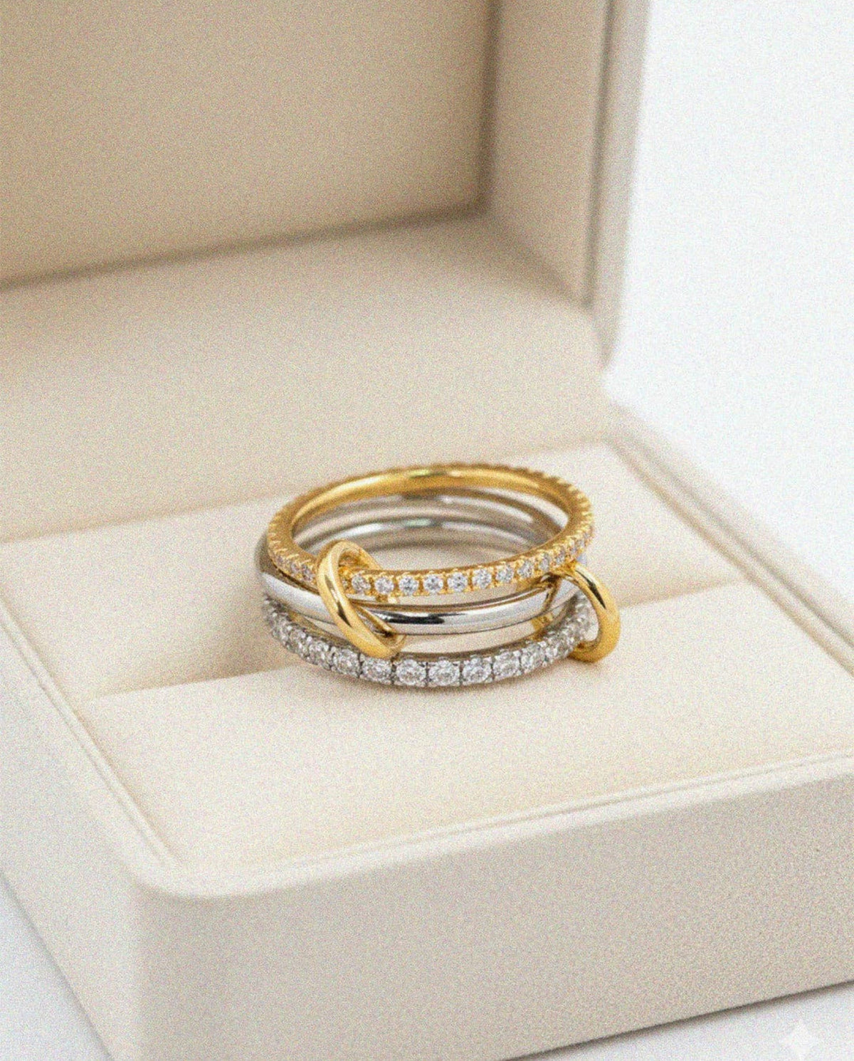 Sculptural interlocking design combining polished bands with crystal-set accents.
